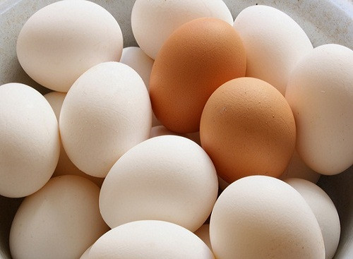 A lots of white and brown chicken eggs close-up