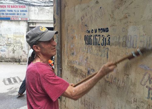 Cựu binh Mỹ cặm cụi gỡ bỏ quảng cáo, rao vặt trên đường phố Hà Nội